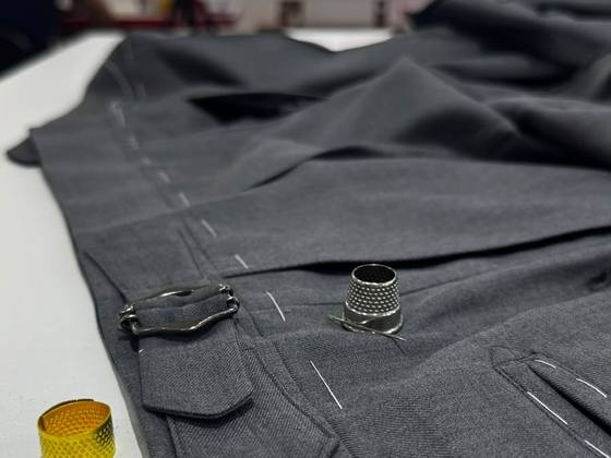 Calça de alfaiataria em prova, com fivela lateral
